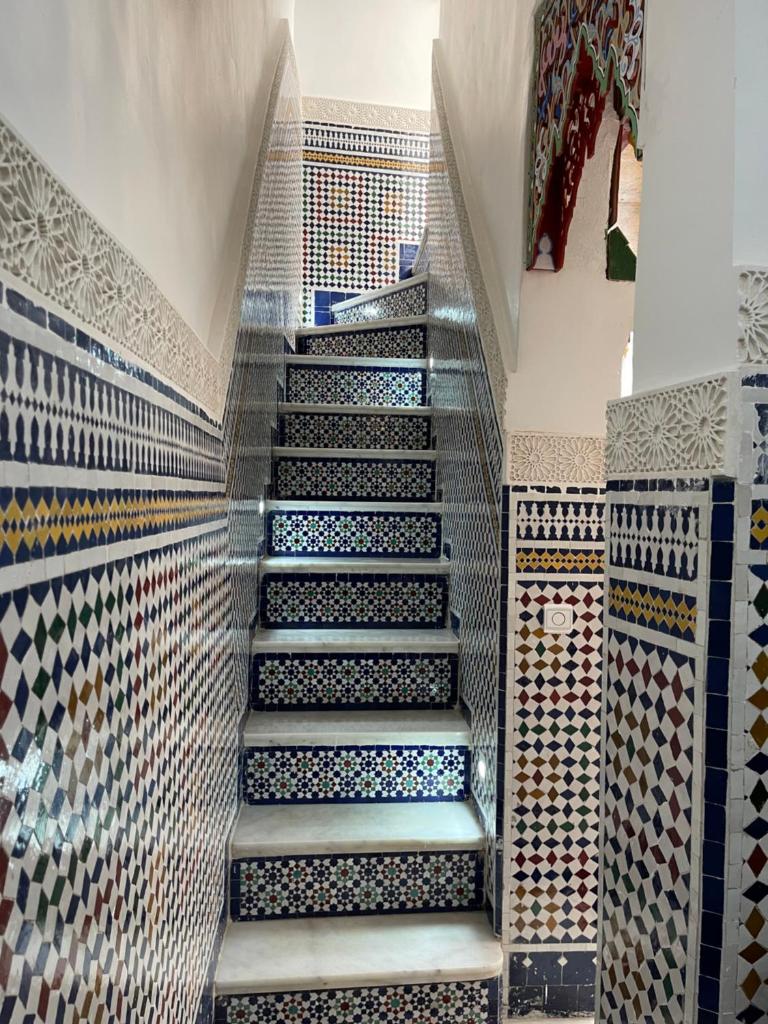 un escalier dans une pièce avec un mur en mosaïque dans l'établissement Riad Shama Fes, à Fès