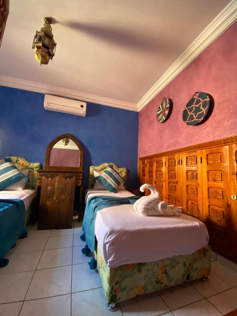une chambre avec deux lits dans une pièce dans l'établissement Riad Tichka piscine palmeraie, à Marrakech