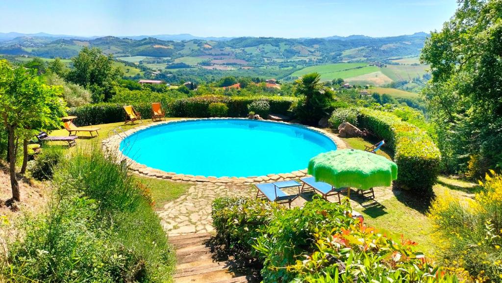une piscine dans un jardin avec des chaises et un parasol dans l'établissement Old House, à Penna San Giovanni