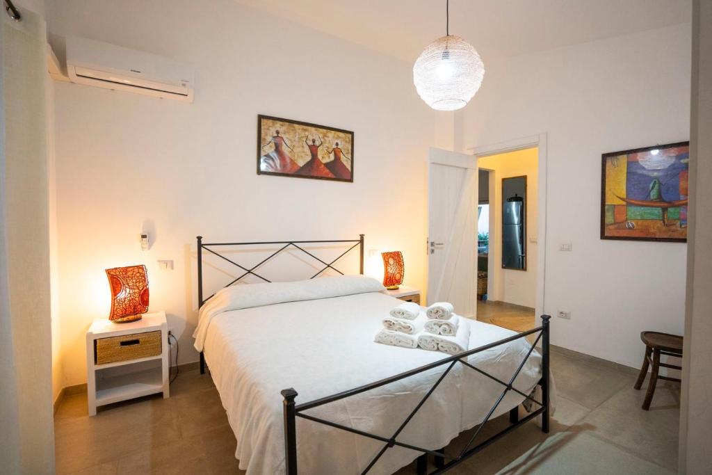 une chambre avec un grand lit blanc et une table dans l'établissement Villa Michaela con piscina privata e vista mare, à Capo Vaticano