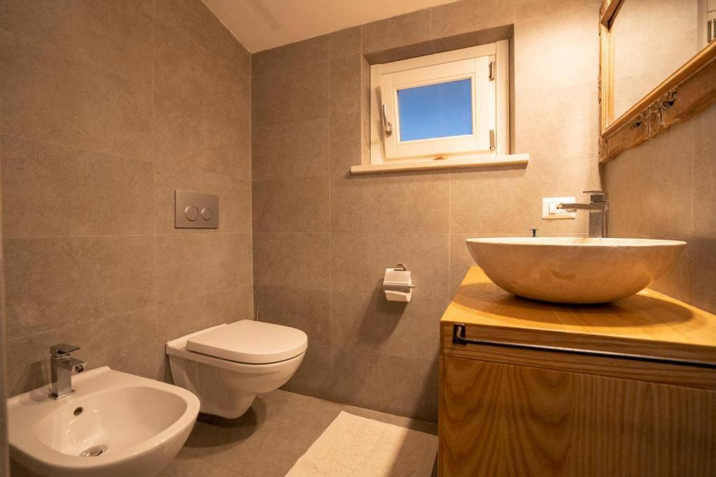 une salle de bain avec un lavabo et des toilettes dans l'établissement Villa Michaela con piscina privata e vista mare, à Capo Vaticano