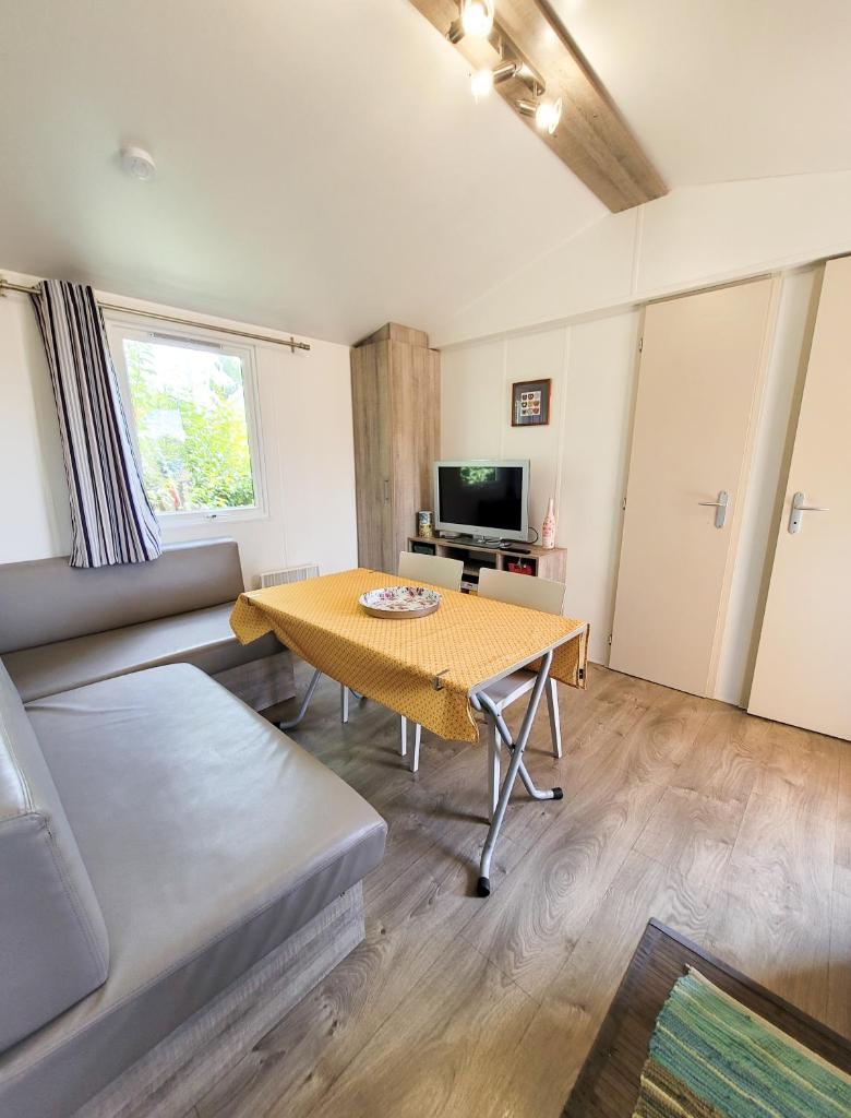 un salon avec une table et un canapé dans l'établissement MOBIL-HOME d'Anne et Edouard, à Argelès-sur-Mer 18 autres photos