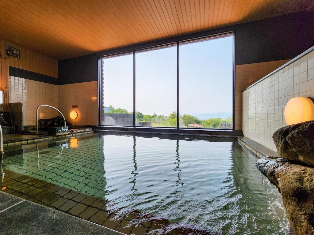 une piscine avec une grande fenêtre dans une maison dans l'établissement Iwanai Kogen Hotel, à Iwanai