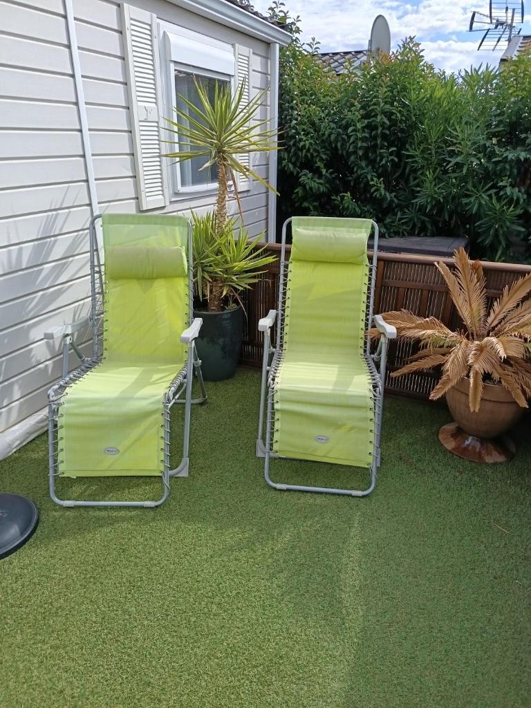 2 chaises longues et une table sur une terrasse dans l'établissement Le petit paradis, à Fréjus