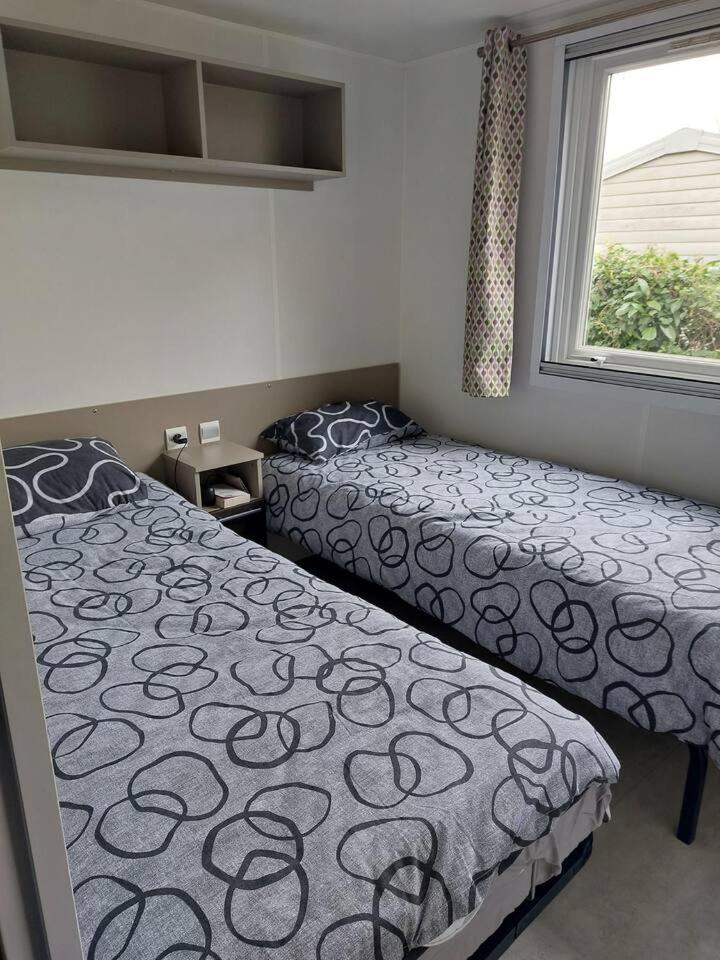une chambre avec deux lits et une fenêtre dans l'établissement Mobilhome N 603 - camping 4étoiles - Tout confort au calme, à Gastes