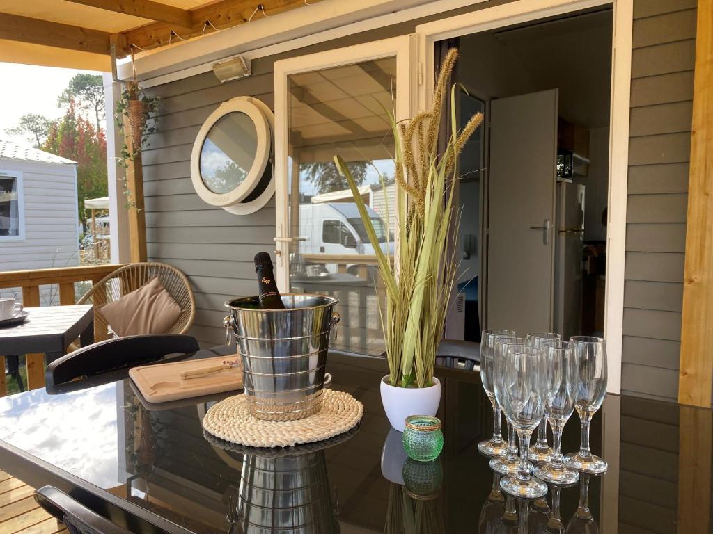 - une terrasse couverte avec des verres à vin et une table dans l'établissement Camping SIBLU Les Viviers 4 étoiles, à Lège-Cap-Ferret