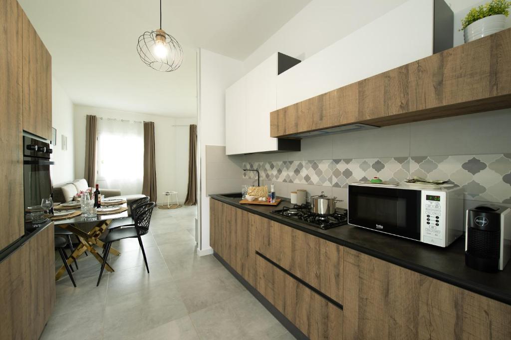 - une cuisine avec un comptoir, un four micro-ondes et une table dans l'établissement Villa Lux, à San Vito Lo Capo