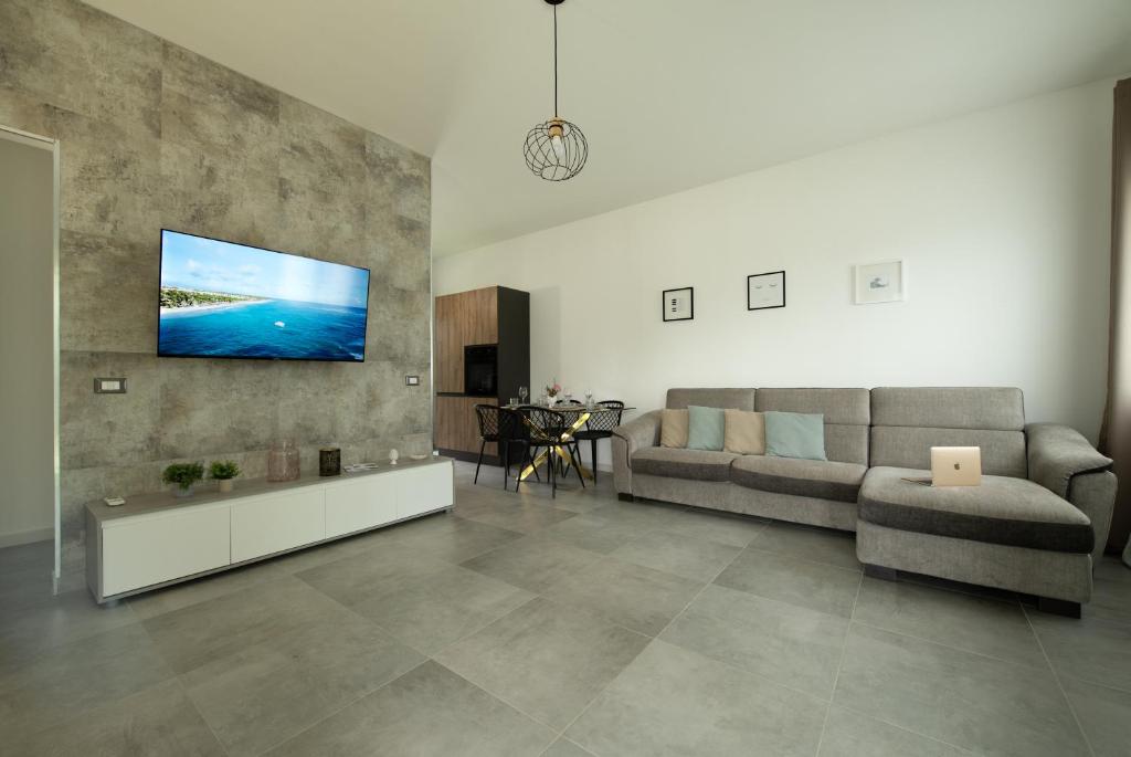 un salon avec un canapé et une télévision sur un mur dans l'établissement Villa Lux, à San Vito Lo Capo