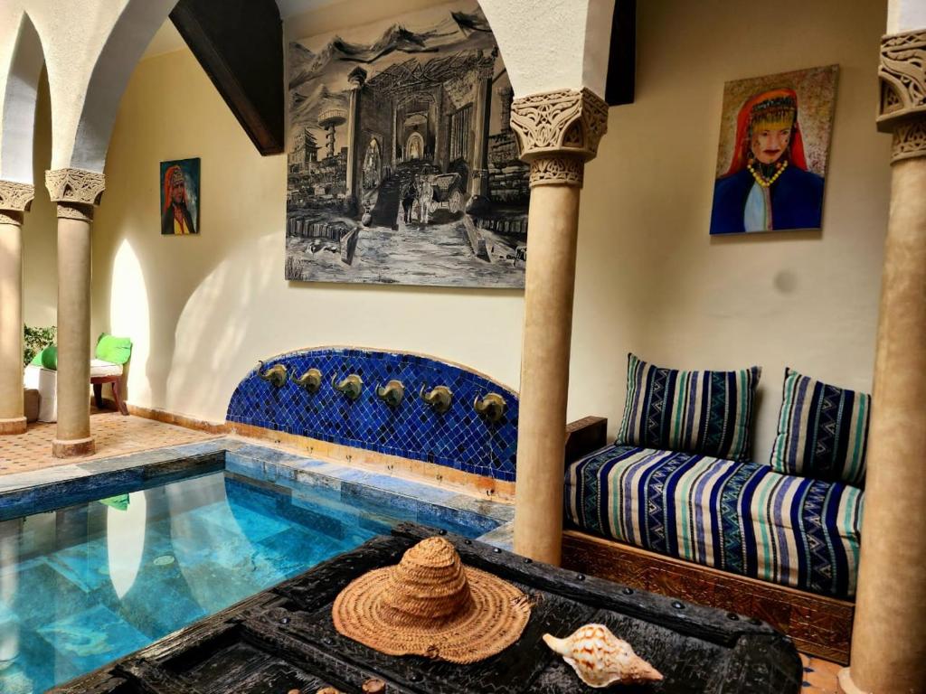 - un salon avec une piscine et un canapé dans l'établissement Riad Rêve d Antan, à Marrakech