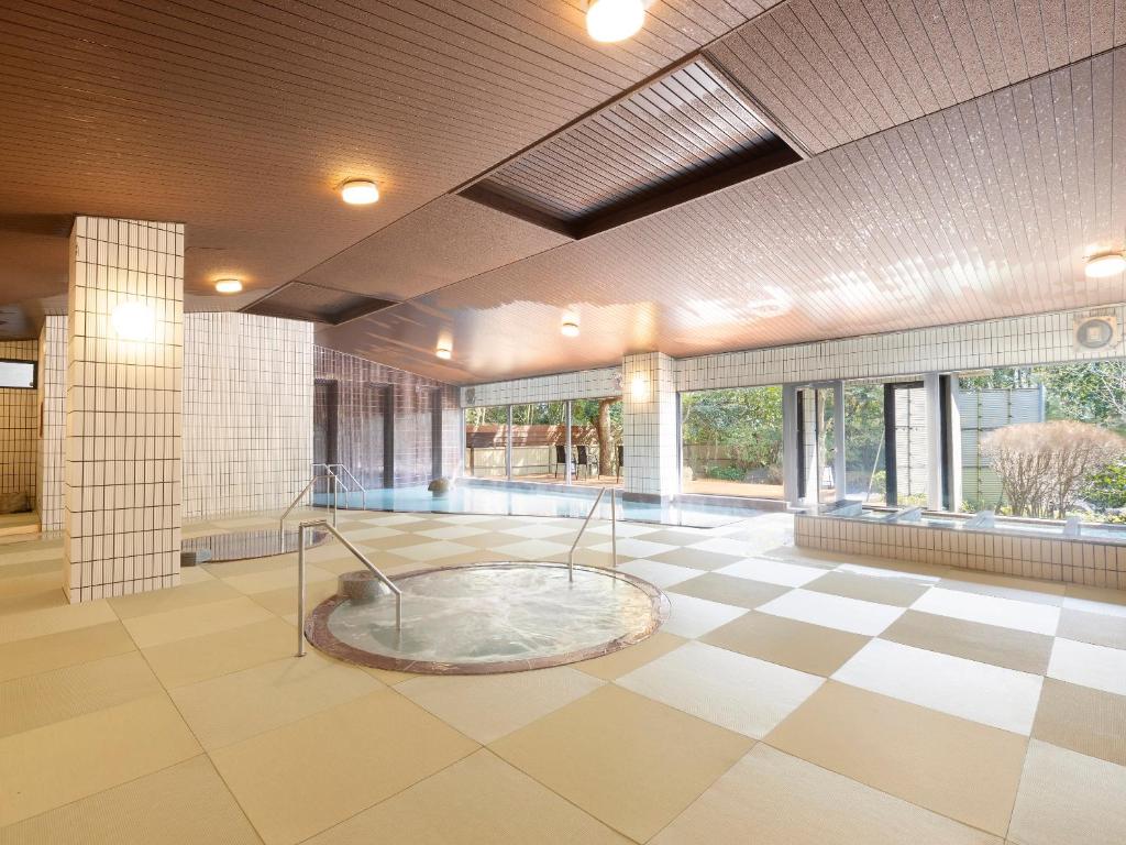 une grande chambre avec baignoire au milieu d'un bâtiment dans l'établissement Ooedo Onsen Monogatari Premium Seiunkaku, à Awara