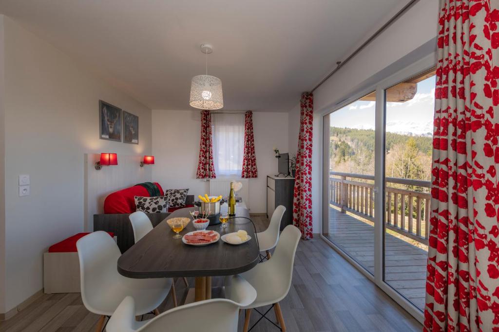 une salle à manger et un salon avec une table et des chaises dans l'établissement Goélia Les Chalets des Pistes, à Combloux
