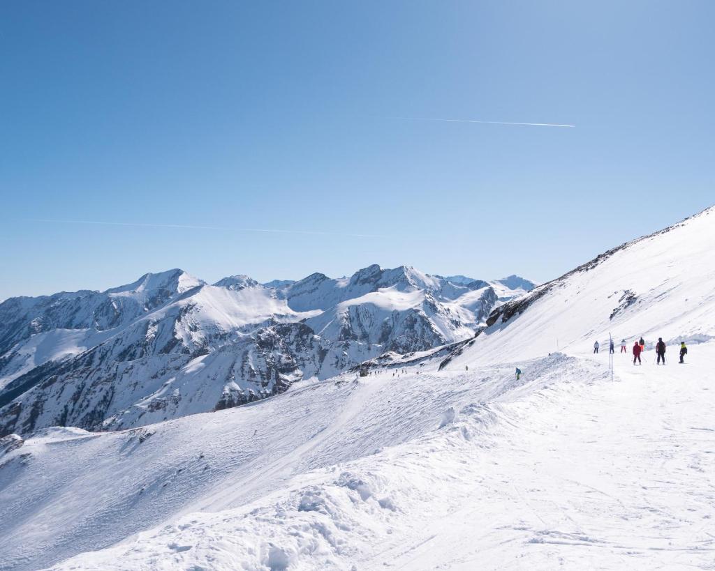 un groupe de personnes skier sur une montagne enneigée dans l'établissement Auberge de Piau, à Aragnouet