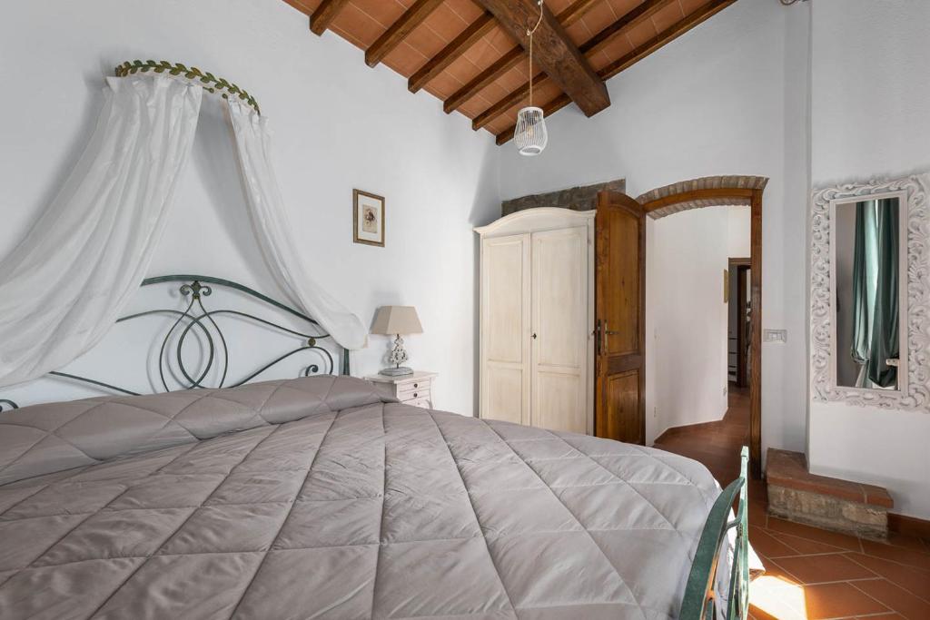 une chambre avec un grand lit dans une pièce dans l'établissement Chianti Villa Chicco, piscina privata, ampio giardino, BBQ e parcheggio, à Greve in Chianti