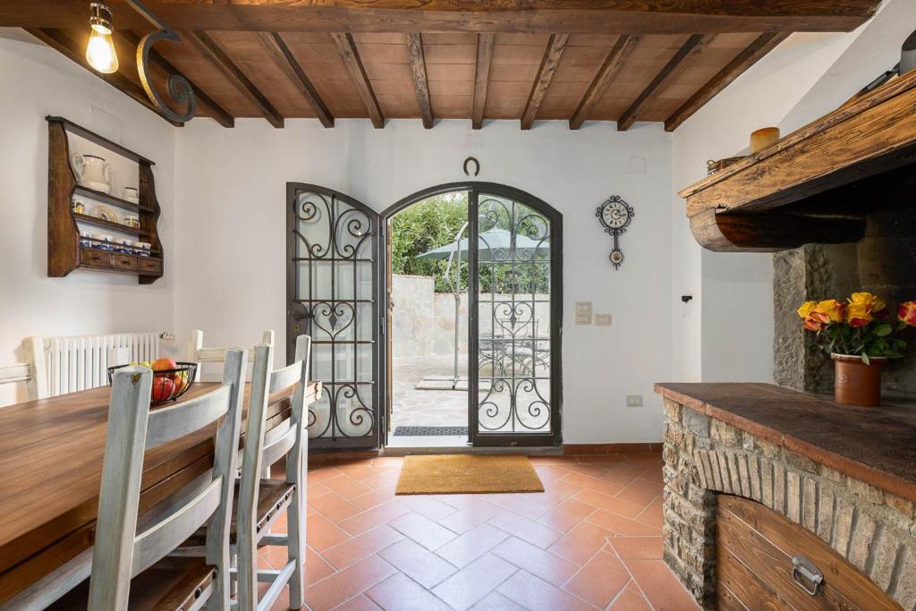 une salle à manger avec une porte ouverte sur une terrasse dans l'établissement Chianti Villa Chicco, piscina privata, ampio giardino, BBQ e parcheggio, à Greve in Chianti
