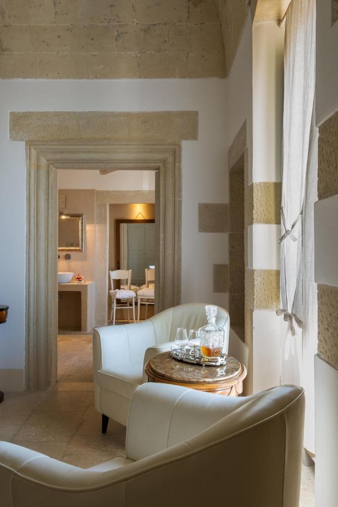 un salon avec un canapé et une table dans l'établissement Palazzo Ducale Venturi - Luxury Hotel & Wellness, à Minervino di Lecce