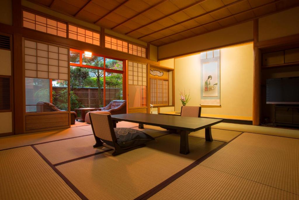 un salon avec une table et des chaises dans l'établissement Hashinoya Bekkan Ransui, à Kobe