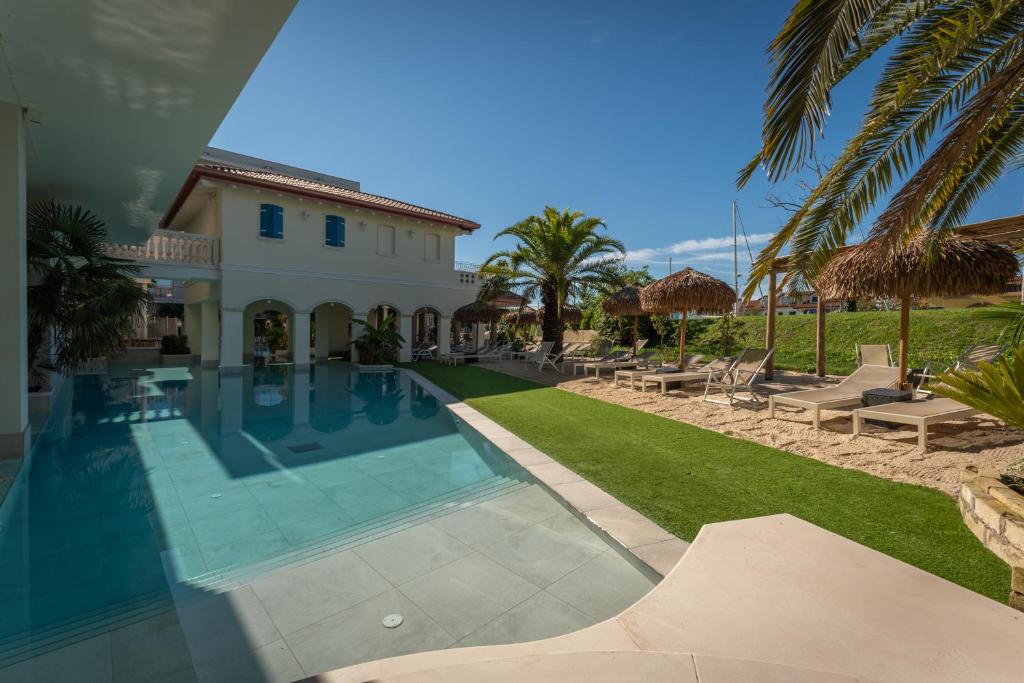 une villa avec piscine et palmiers dans l'établissement AQA Palace, à Caorle
