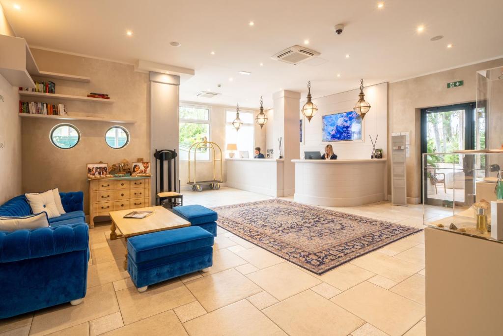 un salon avec un canapé bleu et une table dans l'établissement AQA Palace, à Caorle