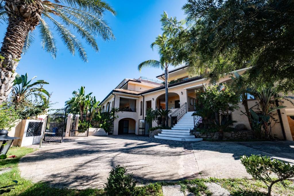 une maison avec des palmiers devant dans l'établissement UNICO Cannamele Escape Tropea by Life Resorts, à Parghelia