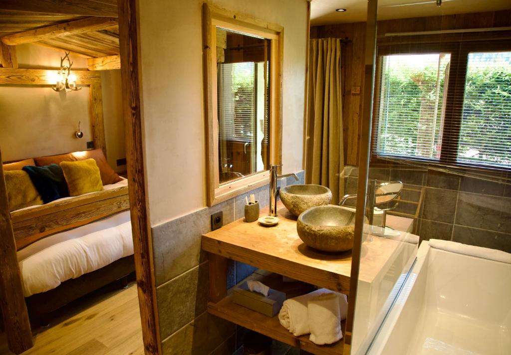 une salle de bain avec baignoire et une chambre avec un lit dans l'établissement Chalets Grands Montets, à Chamonix-Mont-Blanc