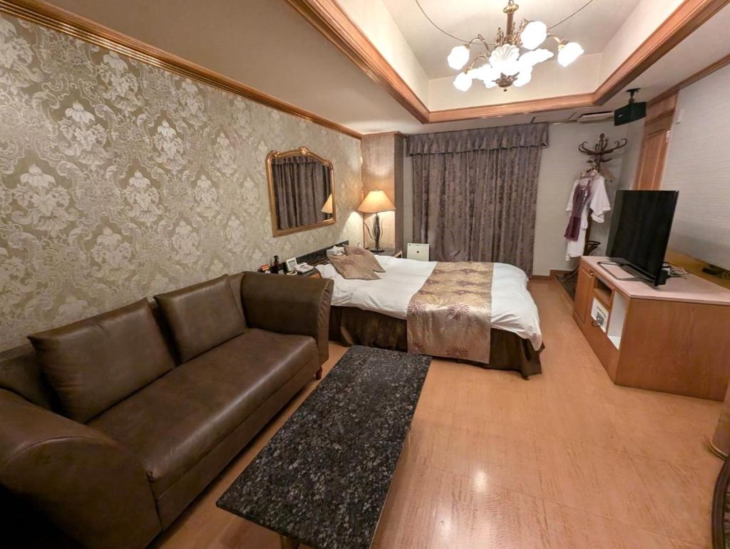 une chambre d'hôtel avec un lit et un canapé dans l'établissement Hotel IRIS -アイリス-, à Osaka