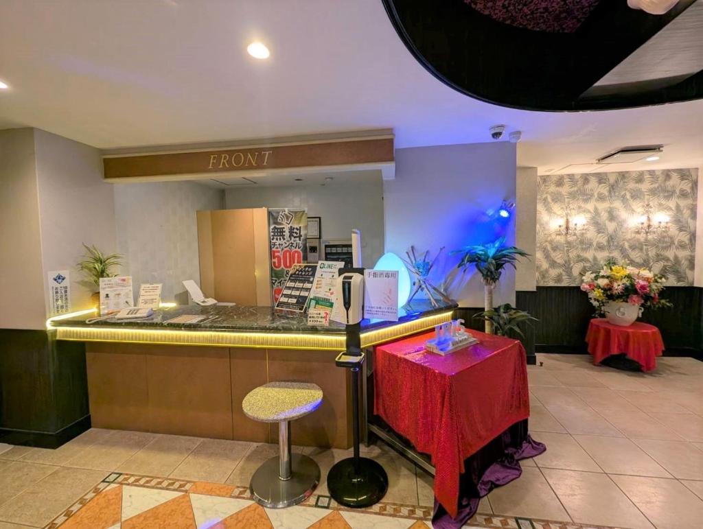 un comptoir d'accueil dans un magasin avec une table et une chaise dans l'établissement Hotel IRIS -アイリス-, à Osaka