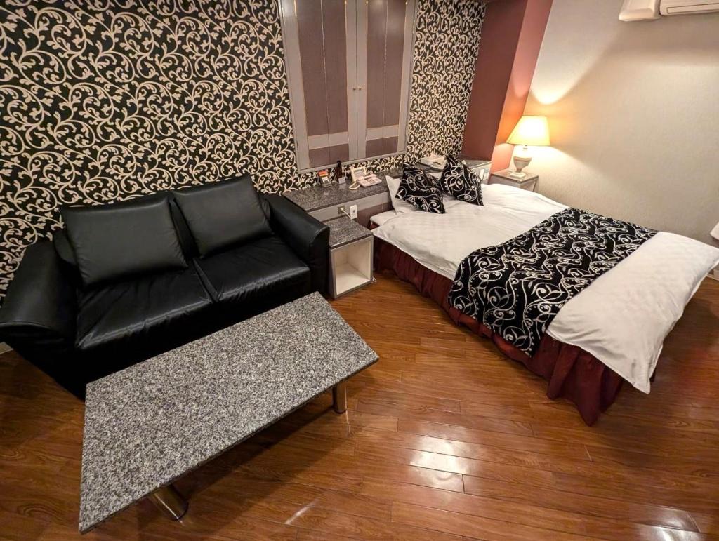 une chambre d'hôtel avec un lit et un canapé dans l'établissement Hotel IRIS -アイリス-, à Osaka 4 autres photos