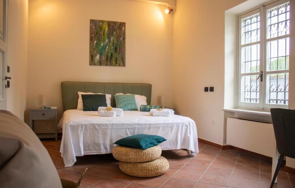 une chambre avec un lit dans une pièce avec des fenêtres dans l'établissement Splendid Villa Magna with Pool and Park - Langhe Hills, à Govone