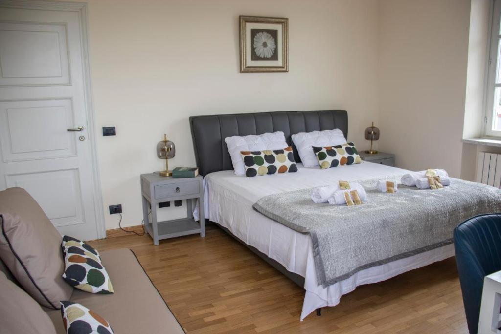 une chambre avec un grand lit avec des oreillers dessus dans l'établissement Splendid Villa Magna with Pool and Park - Langhe Hills, à Govone 92 autres photos