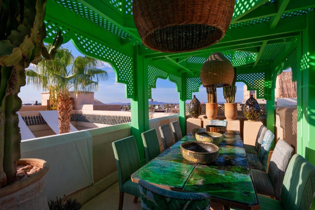 une chambre verte avec une table et des chaises sur un balcon dans l'établissement Riad Due, à Marrakech