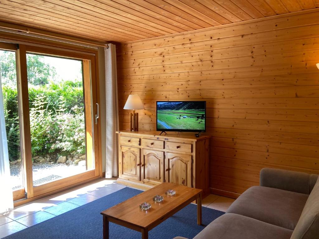 Il comprend un salon doté d'une télévision murale en bois. dans l'établissement La Joly - ChaletYap, à La Chapelle-dʼAbondance