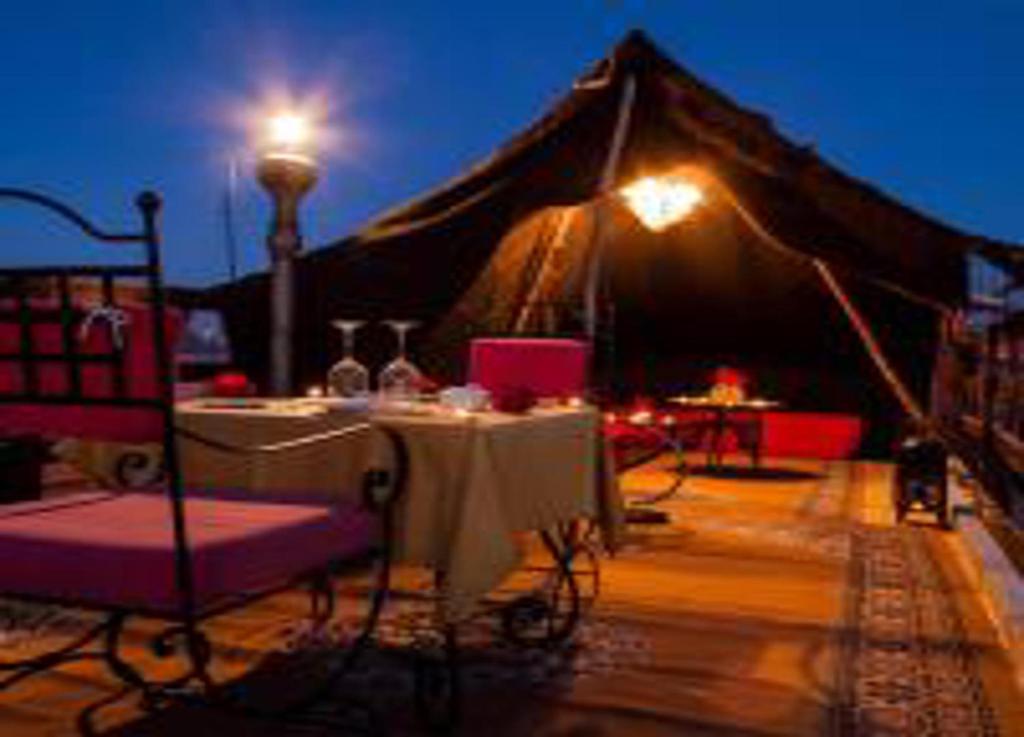 une tente avec une table et des chaises la nuit dans l'établissement Riad Dar El Bacha, à Marrakech