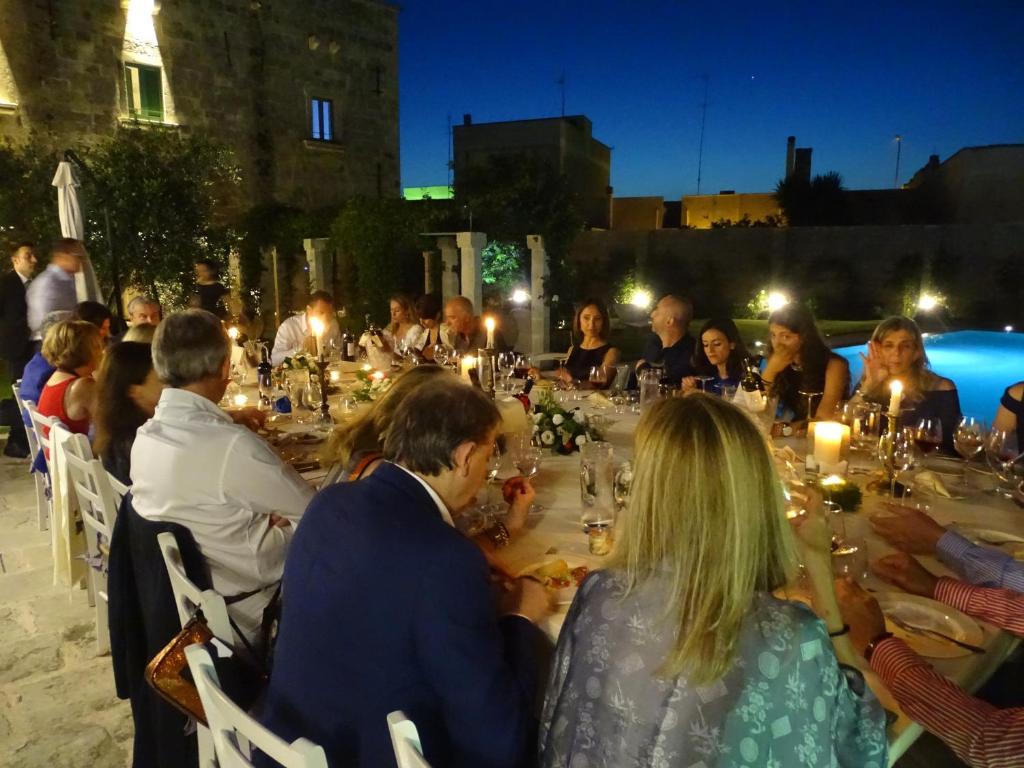 Un groupe de personnes assises à une longue table la nuit dans l'établissement Palazzo Ducale Venturi - Luxury Hotel & Wellness, à Minervino di Lecce 247 autres photos
