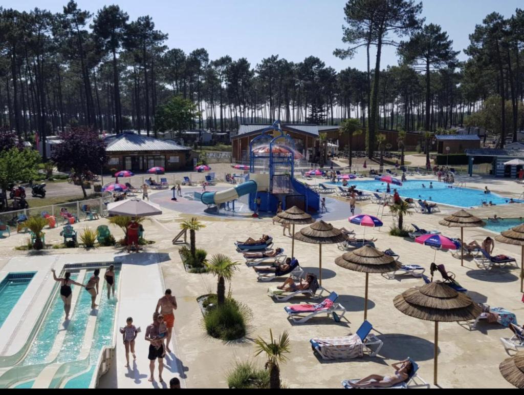 - un groupe de personnes à la piscine d'un complexe dans l'établissement Les dunes de Contis Chez Edith océan pins et détente assurée dans camping 4 étoiles, à Saint-Julien-en-Born