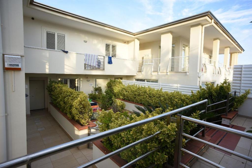 Elle comprend un balcon offrant une vue sur un bâtiment orné de plantes. dans l'établissement THE FLOWERs, à Pontecagnano