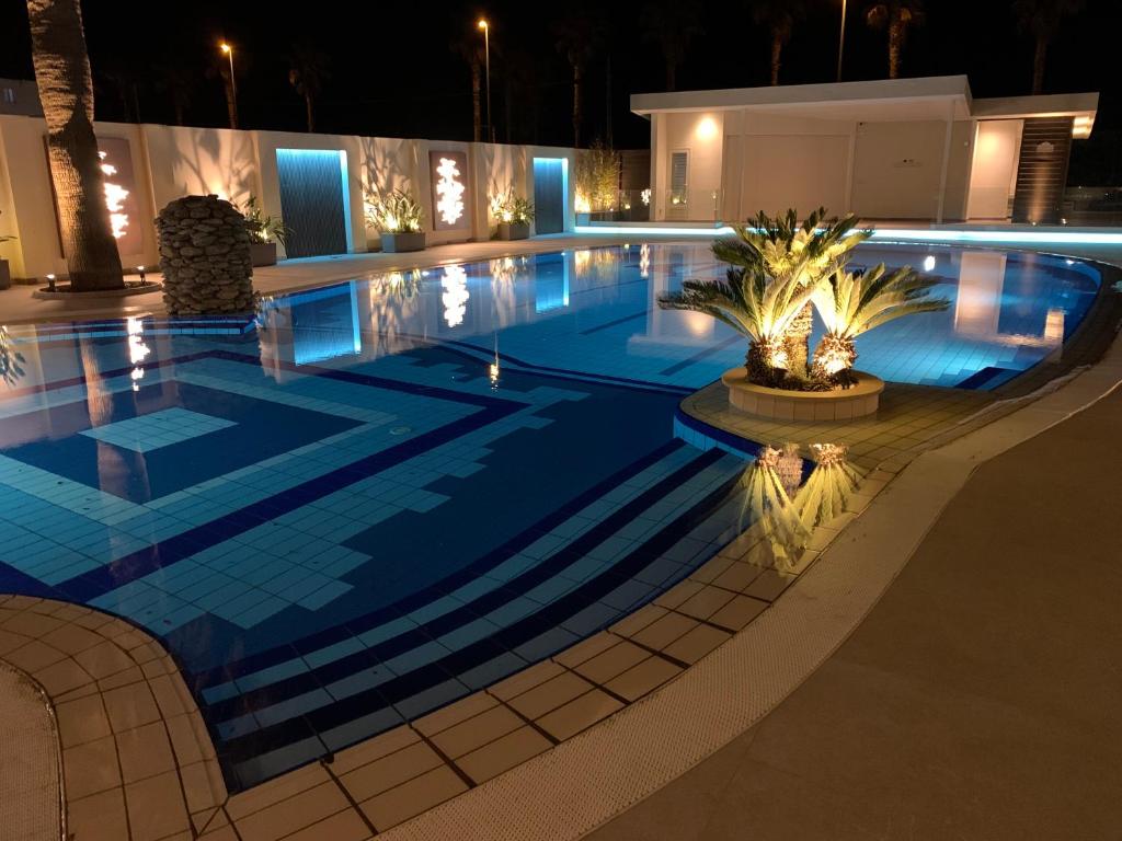 - une grande piscine avec éclairage bleu la nuit dans l'établissement THE FLOWERs, à Pontecagnano