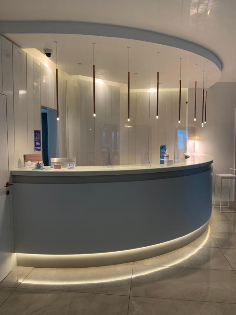 un hall d'entrée avec un long comptoir éclairé dans l'établissement THE FLOWERs, à Pontecagnano