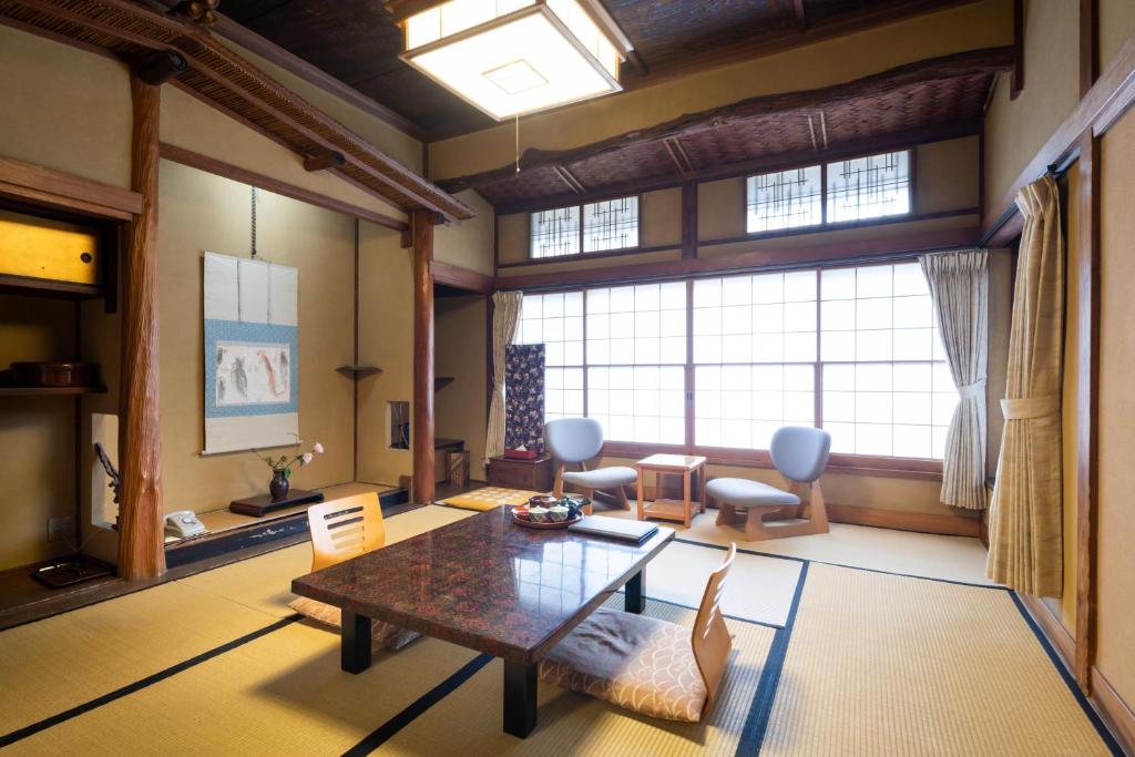 un grand salon avec une table et des chaises dans l'établissement Gensen Uenoya, à Yugawara