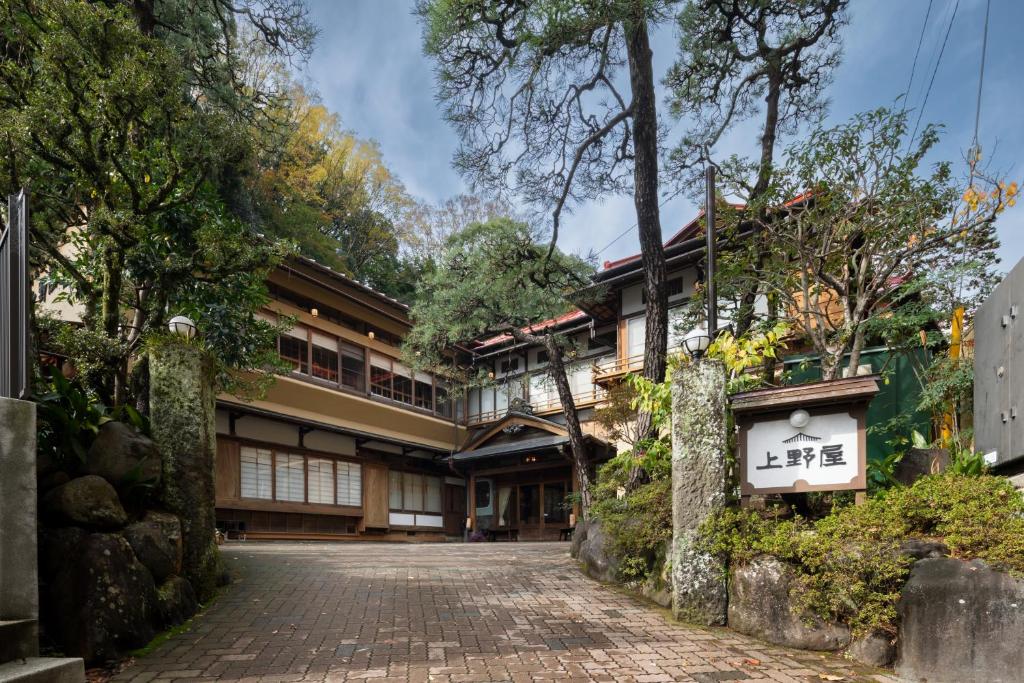 une maison avec une route en briques devant un bâtiment dans l'établissement Gensen Uenoya, à Yugawara