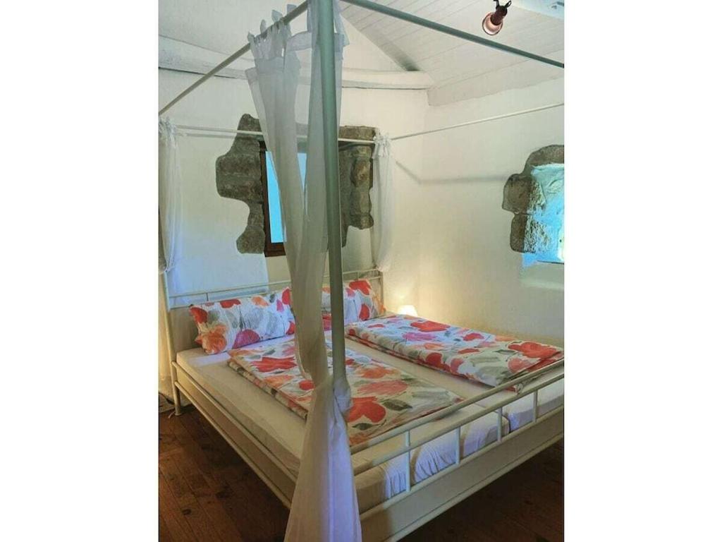 - un petit lit dans une chambre avec rideau dans l'établissement La Patouille Comfortable holiday residence, à Aujac 33 autres photos