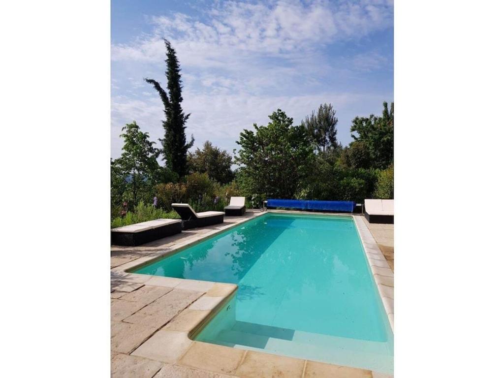 une piscine avec de l'eau bleue dans une cour dans l'établissement La Patouille Comfortable holiday residence, à Aujac