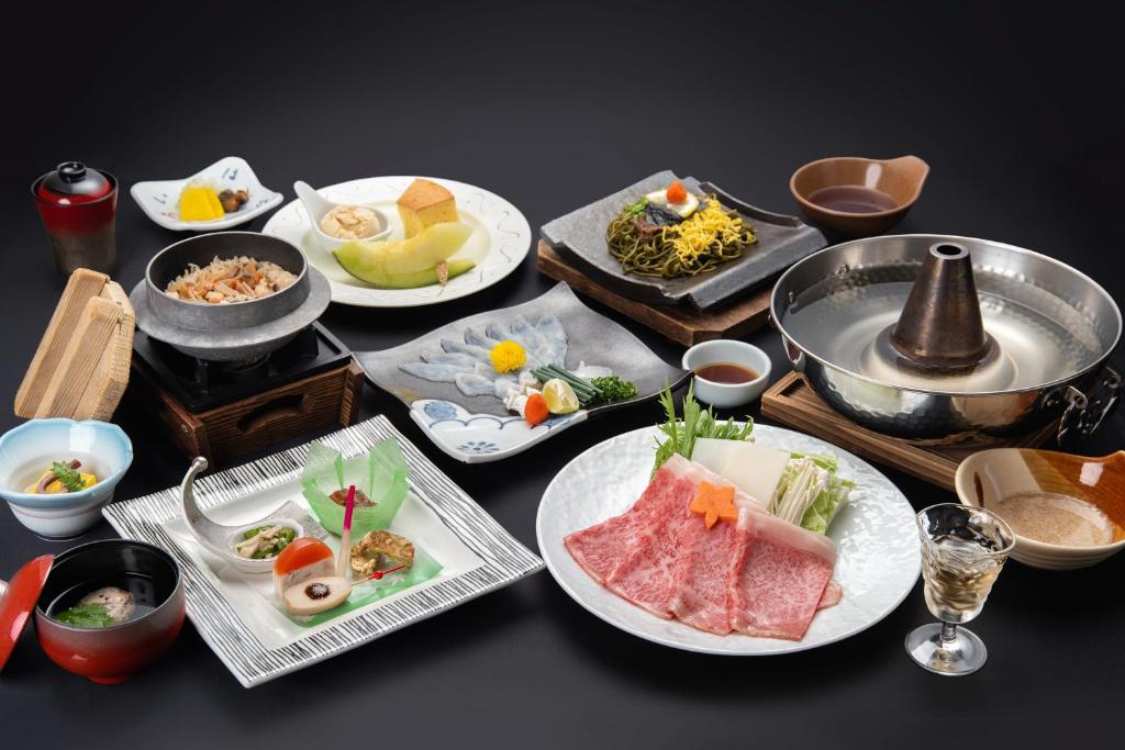 une table recouverte de assiettes de nourriture et d'autres plats dans l'établissement Kotengu Sanroji, à Shimonoseki