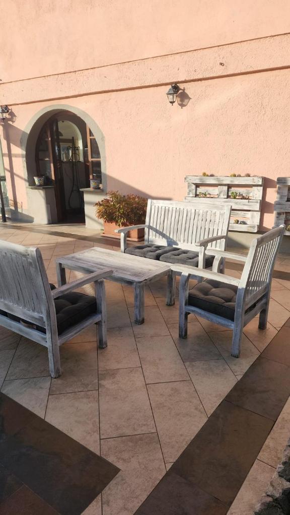 3 bancs en bois assis à côté d'un bâtiment dans l'établissement Locanda Il Senatore, à Fiascherino 66 autres photos