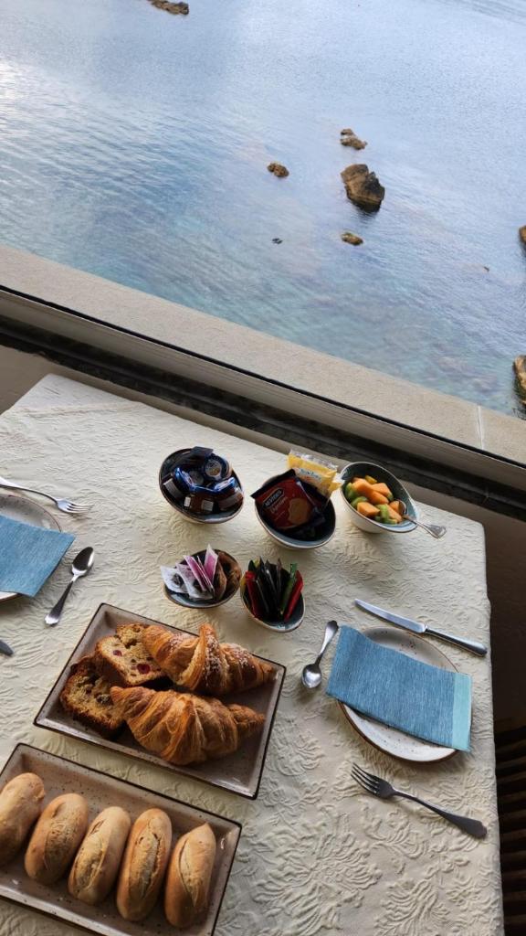 - une table avec de la nourriture et une vue sur l'eau dans l'établissement Locanda Il Senatore, à Fiascherino