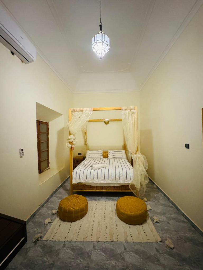 - une chambre avec un lit et deux ottomanes dans l'établissement Riad Kasbah Ben Hamo, à Nkob