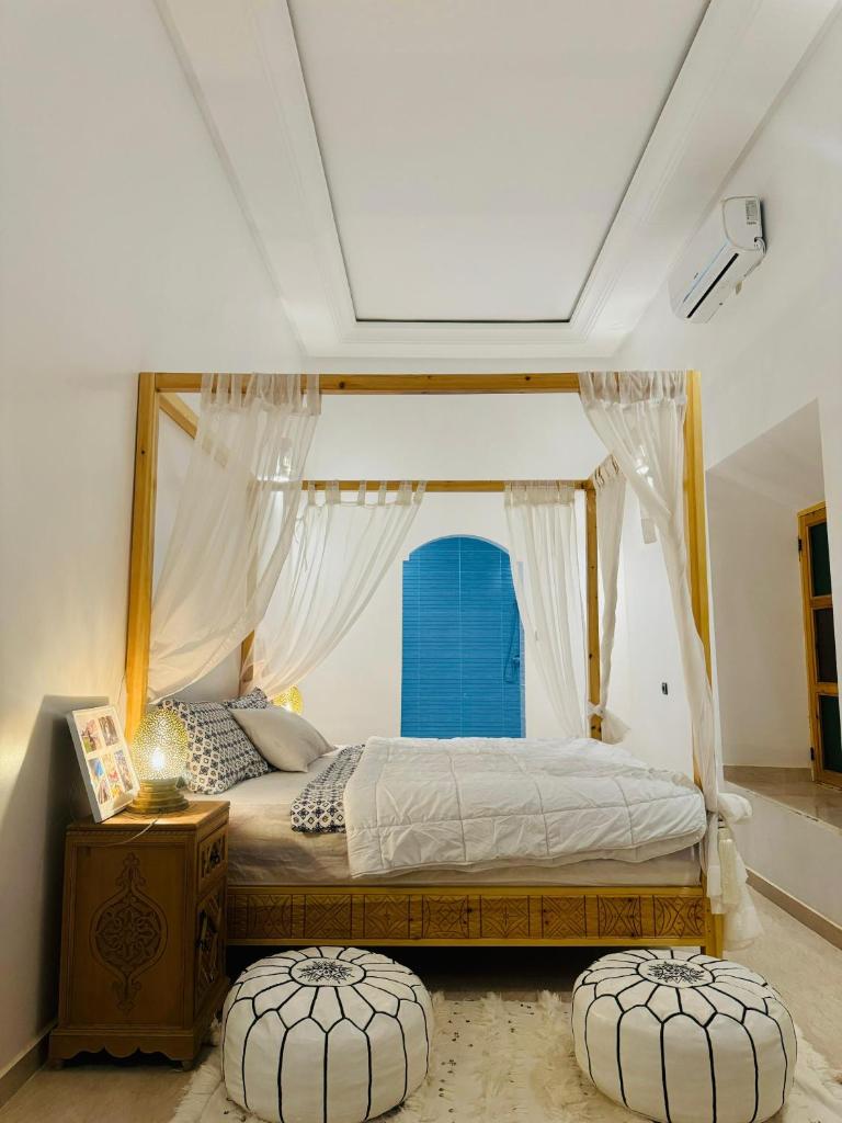 - une chambre avec un lit à baldaquin et une fenêtre dans l'établissement Riad Kasbah Ben Hamo, à Nkob
