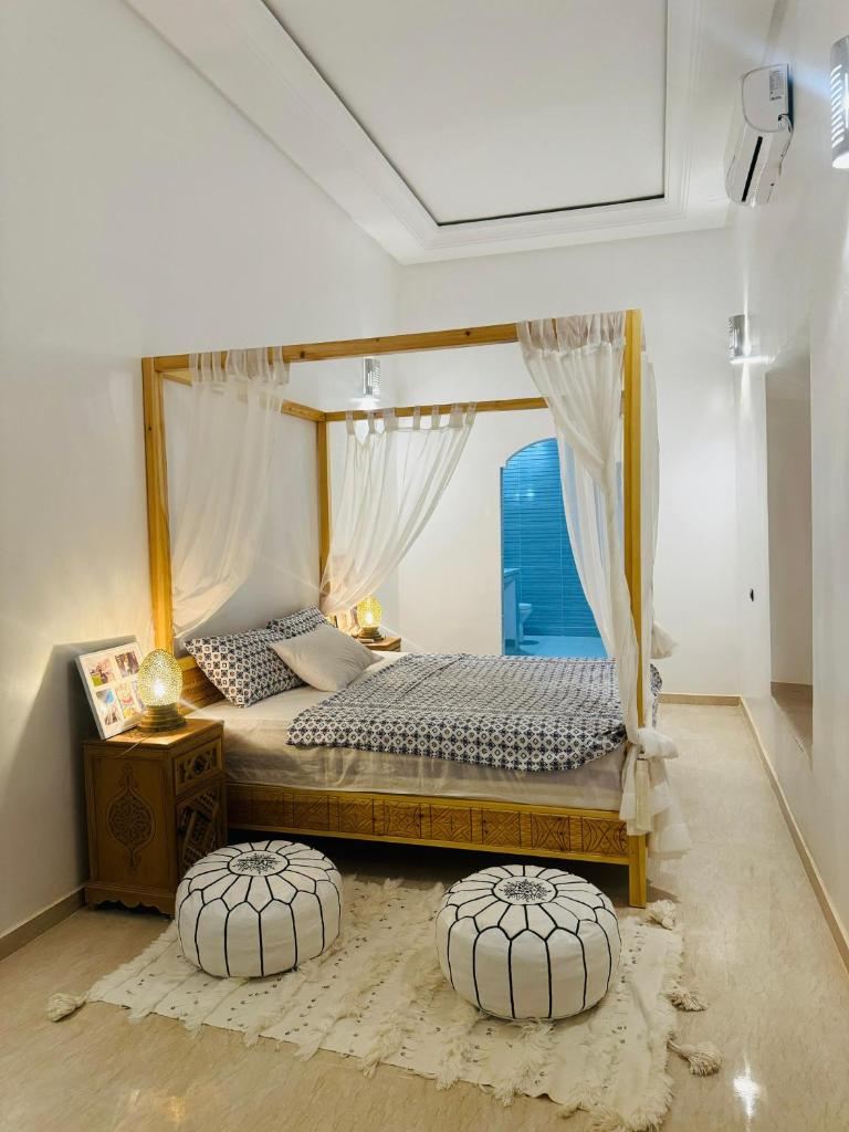 - une chambre avec un lit à baldaquin dans l'établissement Riad Kasbah Ben Hamo, à Nkob