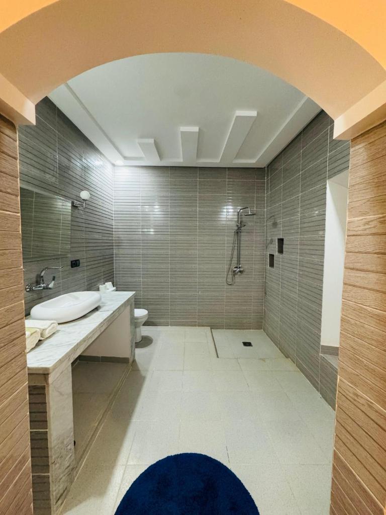 une salle de bain avec une baignoire, un lavabo et une douche dans l'établissement Riad Kasbah Ben Hamo, à Nkob