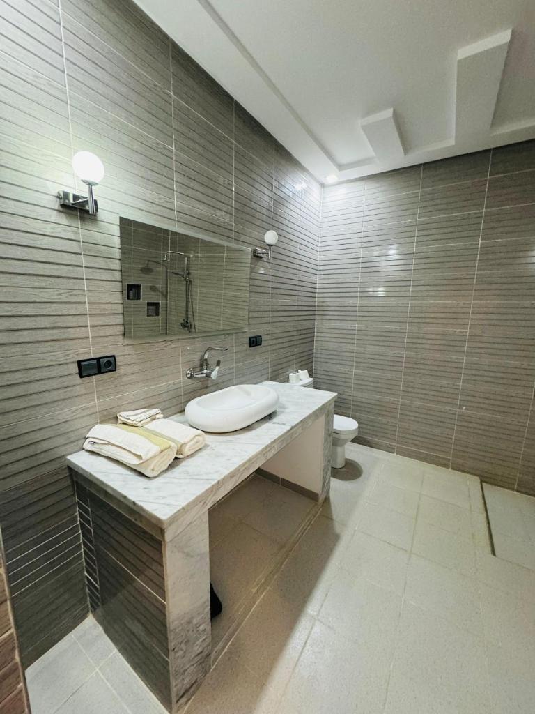 une salle de bain avec un lavabo et des toilettes dans l'établissement Riad Kasbah Ben Hamo, à Nkob 24 autres photos