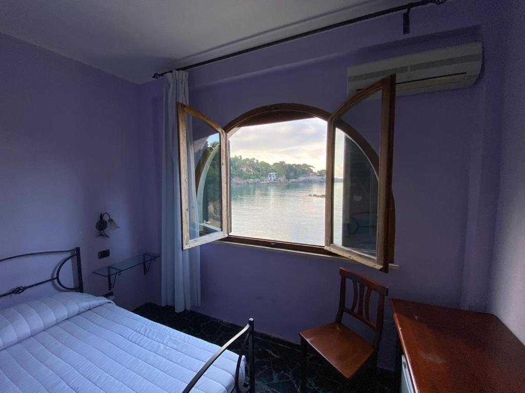 une chambre avec une fenêtre avec vue sur l'eau dans l'établissement Locanda Il Senatore, à Fiascherino